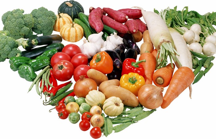 A large assortment of fresh vegetables arranged in a heart shape