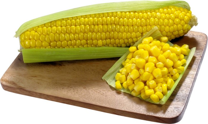 Corn on the cob and kernels on a wooden board