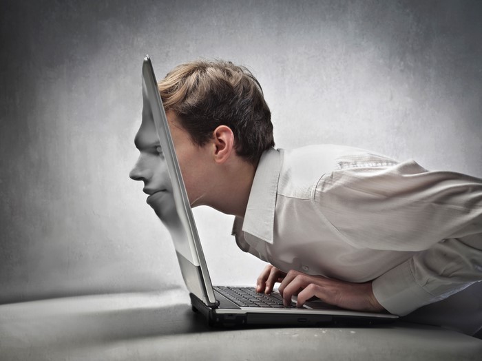 Man's face emerging from laptop screen