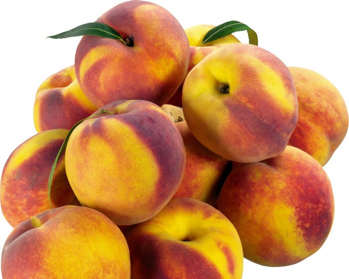 Pile of ripe peaches with leaves