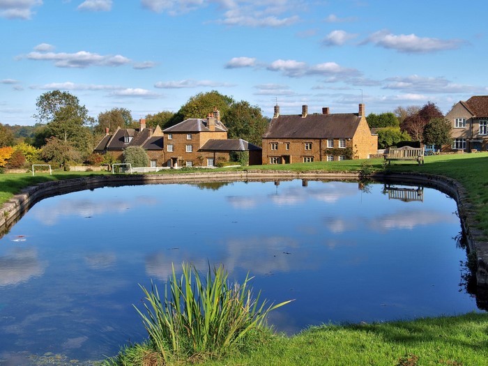 Village pond with houses and trees in the United Kingdom