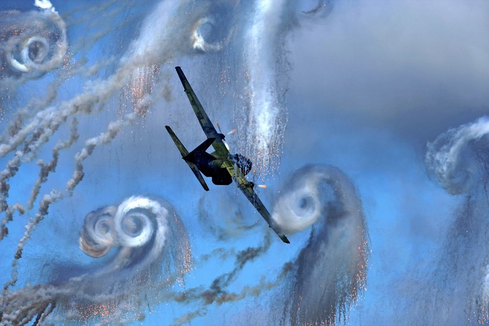 Airplane performing aerobatics with smoke trails
