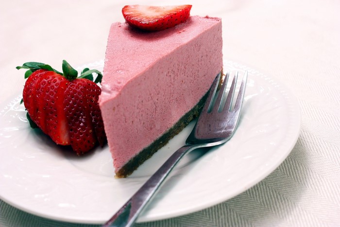 Strawberry cheesecake slice with fresh strawberries and fork