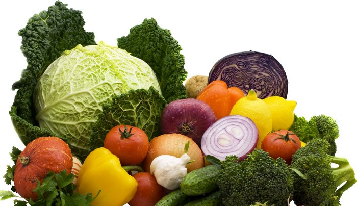 Assortment of fresh vegetables including cabbage, tomatoes, broccoli, and onions