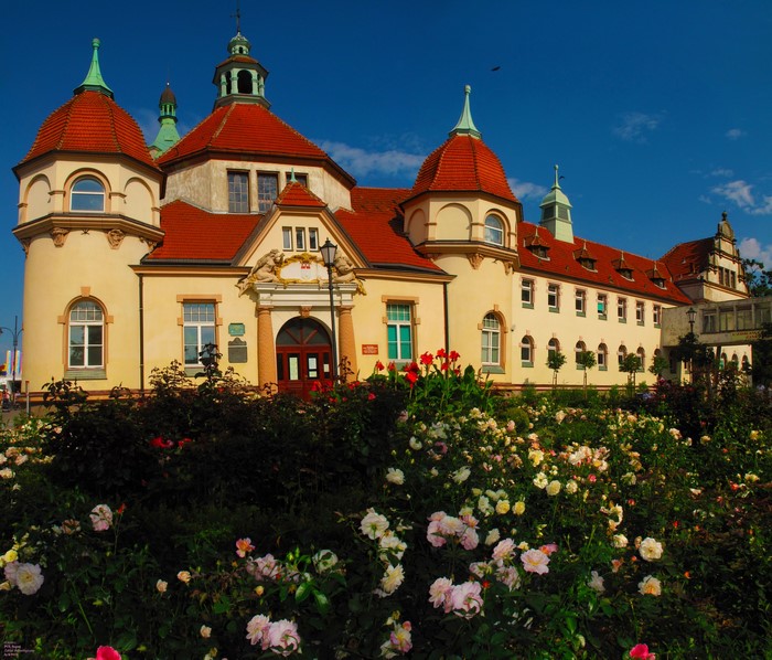 Building with red roof and rose garden in Poland