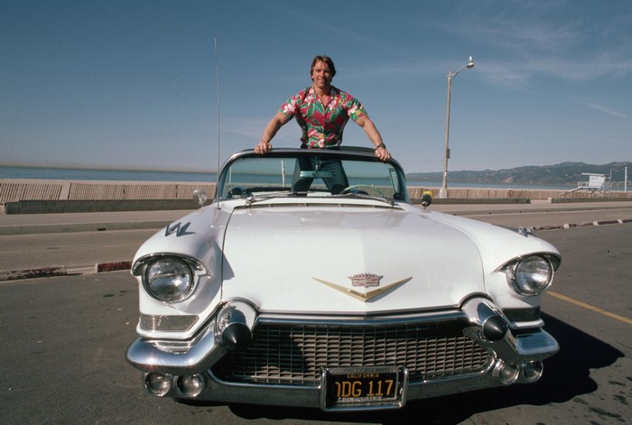 Arnold Schwarzenegger in a convertible Cadillac