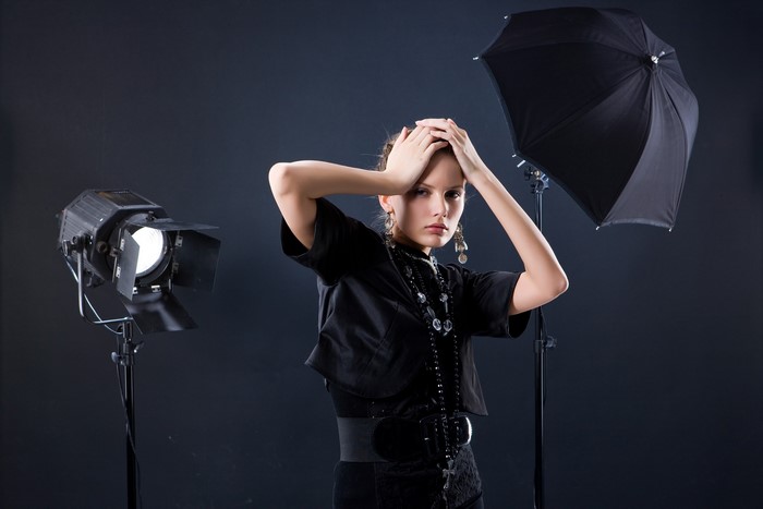 Woman posing with studio lighting and umbrella