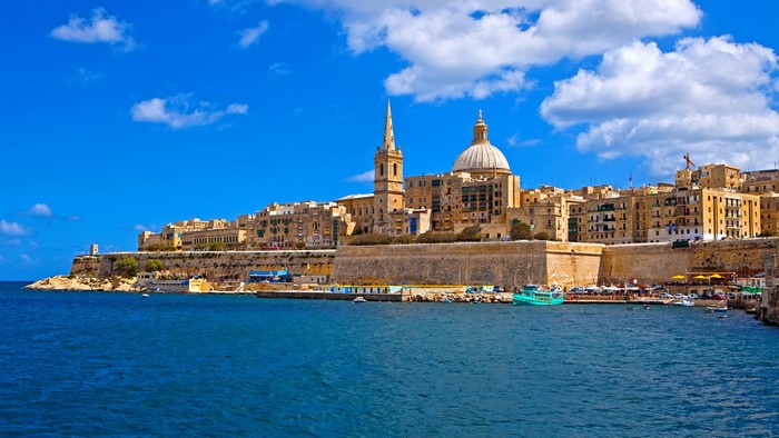 Valletta, Malta waterfront with historic buildings and blue sky