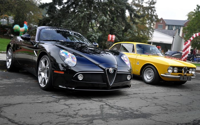 Two Alfa Romeo cars parked on asphalt