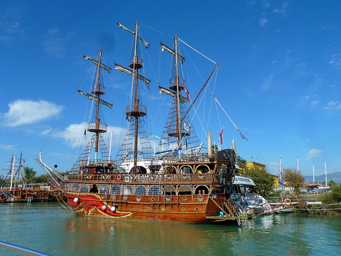 Wooden pirate ship sailing on turquoise water