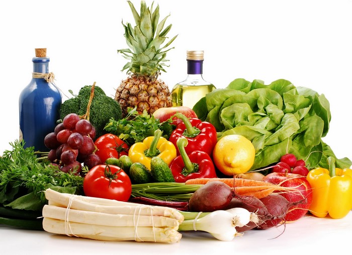 Assortment of fresh fruits and vegetables with oil bottles