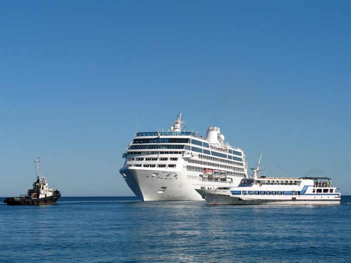 Pacific Princess cruise liner and tugboat at sea