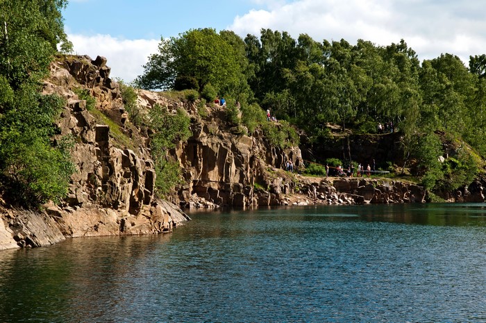People jumping into a quarry lake