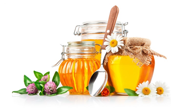 Honey in jars with flowers and spoon
