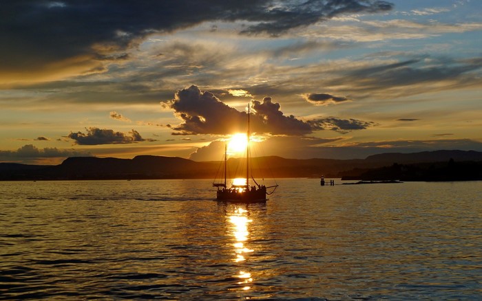 Sailboat on the water at sunset in Oslo, Norway