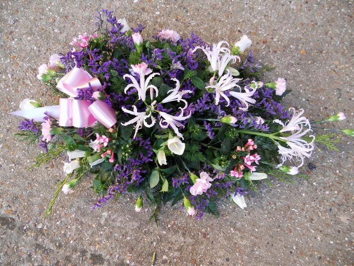Funeral flower arrangement with pink bow