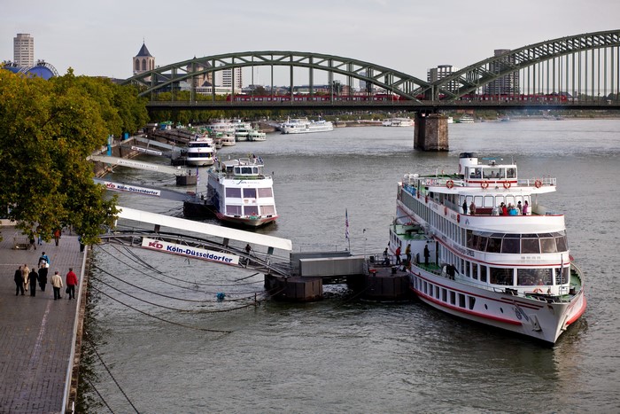Ships docked at a pier under a bridge