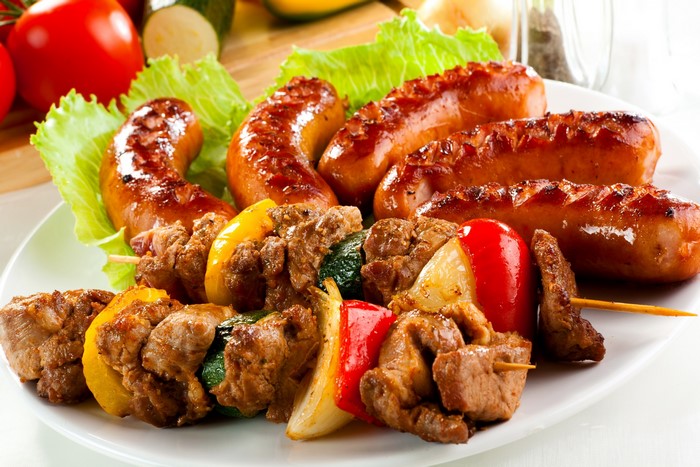 Grilled sausages and meat skewers with vegetables