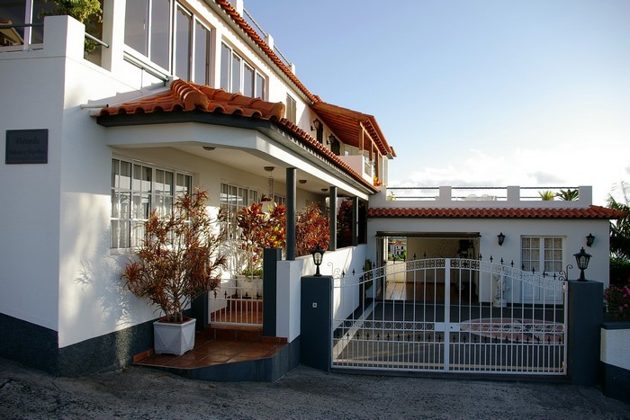 White house with red tile roof and white gate in Portugal