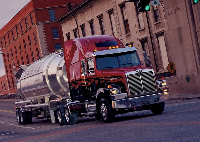 Red Western Star tanker truck driving on a city street
