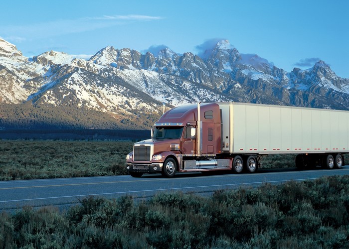 Freightliner Truck driving on a road with mountains