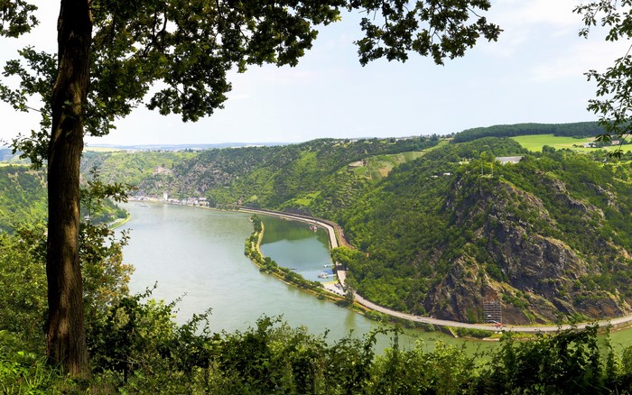 River valley with steep green hills and a town