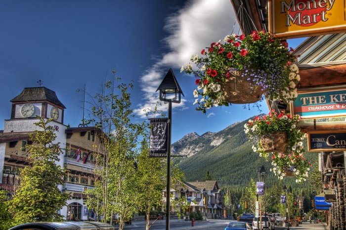 Street scene in Banff, Canada with mountains and clock tower