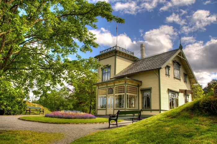 Yellow house in Norway with garden and benches