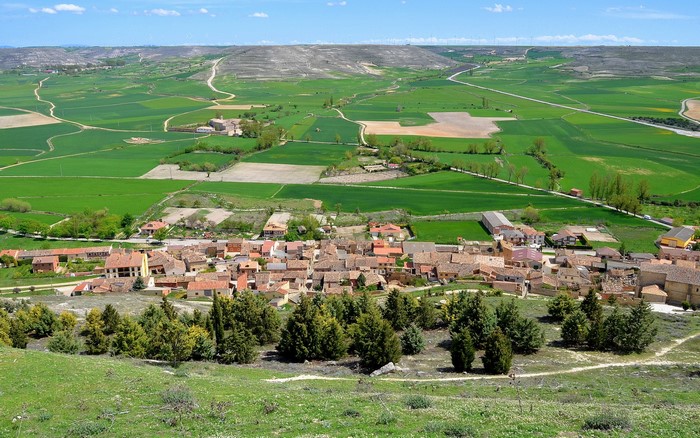 Aerial view of a Spanish village surrounded by green fields