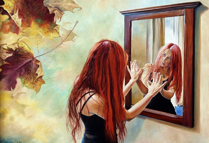 Woman with red hair looking in a mirror