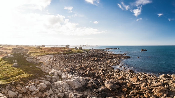Rocky coastline with a lighthouse in the distance