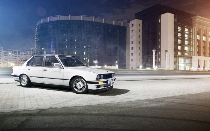 White BMW E30 sedan parked at night