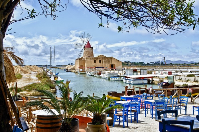 Windmill and boats in a canal in Italy