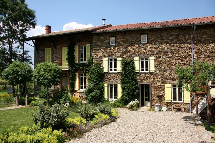 Stone house with yellow shutters in France