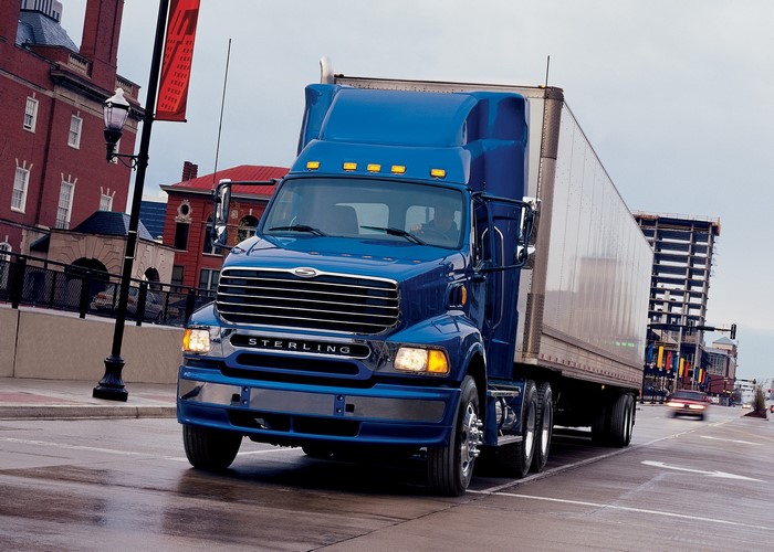 Blue Sterling semi-truck with trailer on city street
