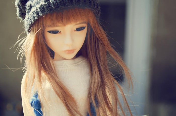 Doll wearing a beanie and sweater
