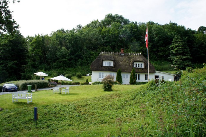 Thatched roof house with Danish flag in Denmark