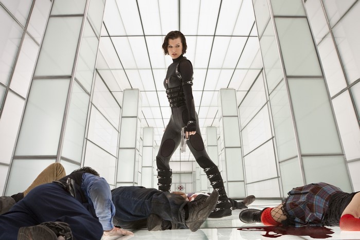 Alice from Resident Evil in a futuristic hallway with fallen bodies