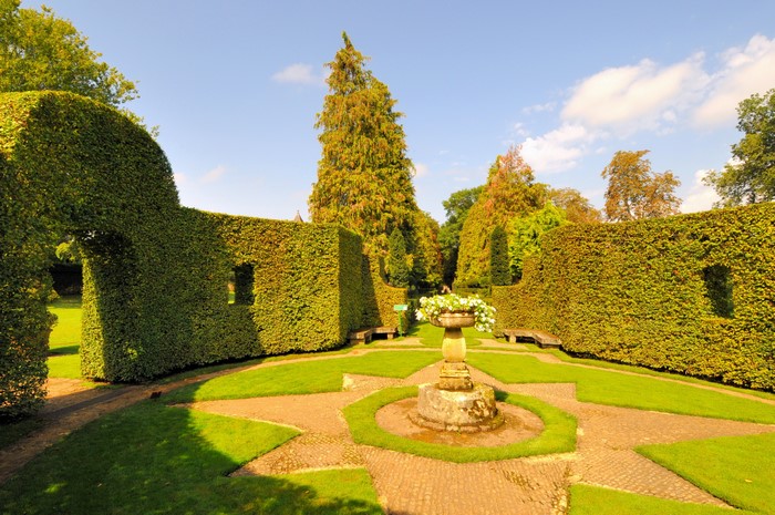 Formal garden with sculpted hedges and a sundial