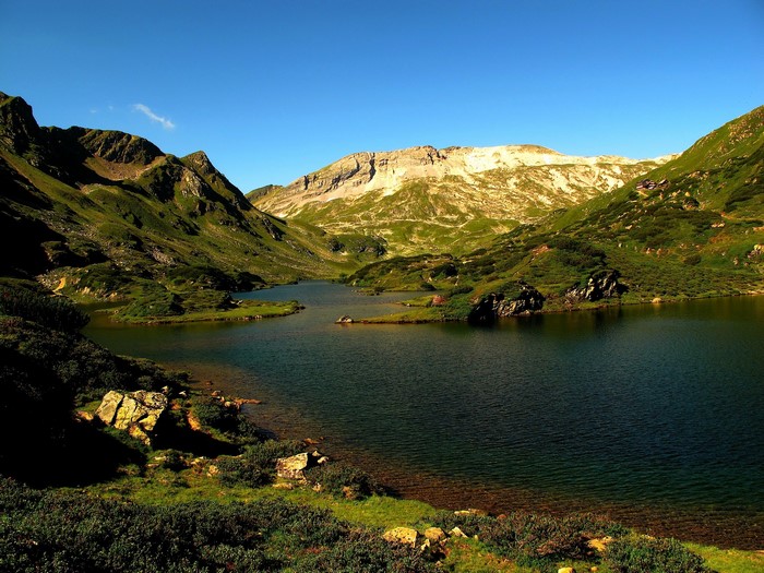 Lake and mountains under a clear blue sky