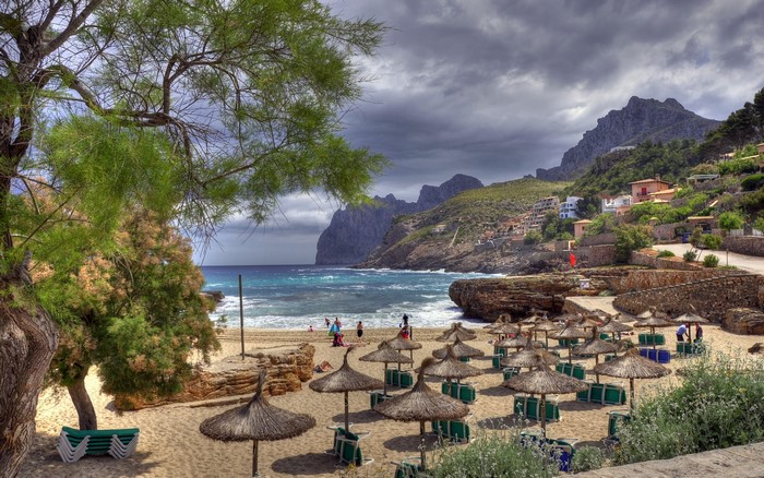Beach with umbrellas and mountains in Spain