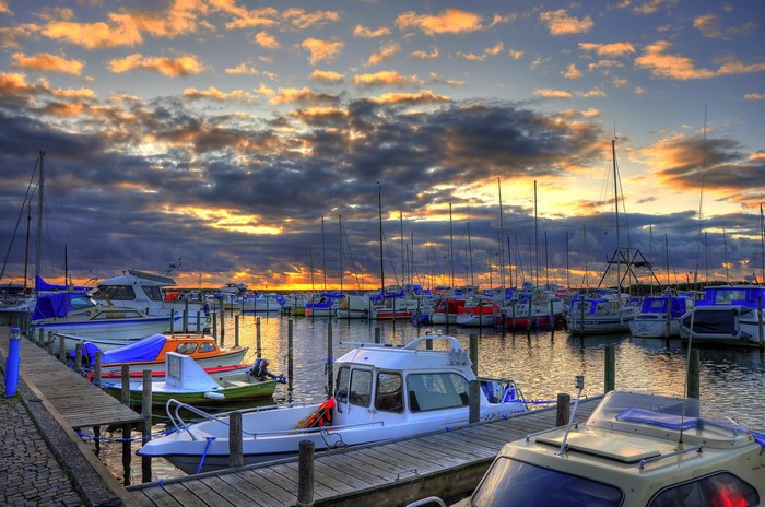 Boats docked in a harbor at sunset