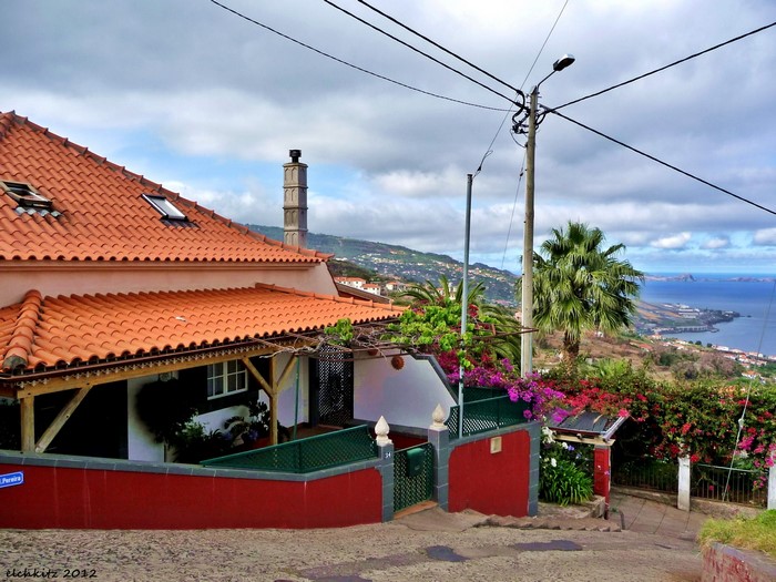 House with red walls and orange roof overlooking the sea