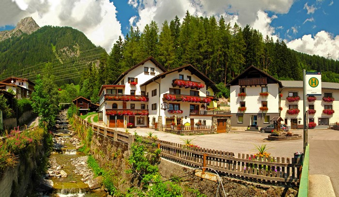 Alpine village with stream and mountains