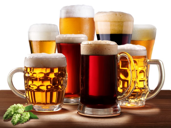Collection of assorted beers in mugs and glasses