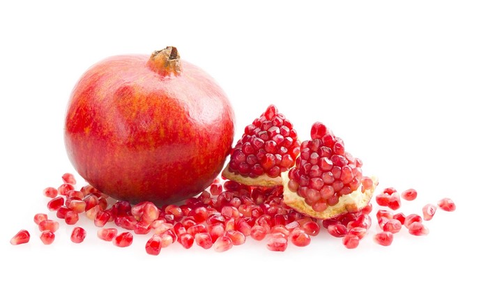Whole and cut pomegranates with seeds