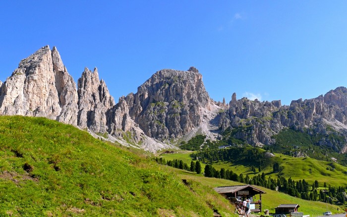 Rocky mountains with green hills and a small wooden building