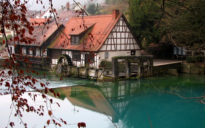 Half-timbered mill building on a turquoise river in Germany