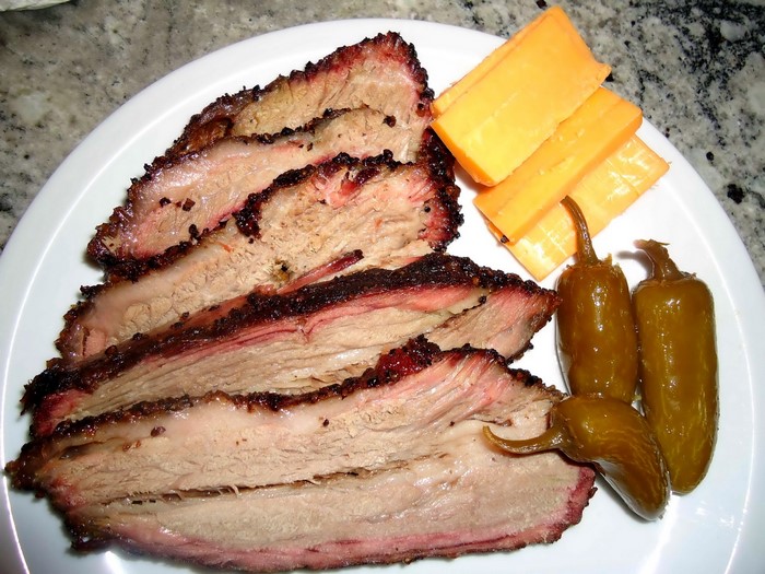 Sliced smoked brisket with cheese and pickled jalapeños
