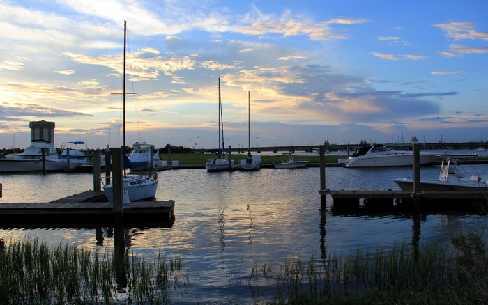 Boats docked in a harbor at sunset